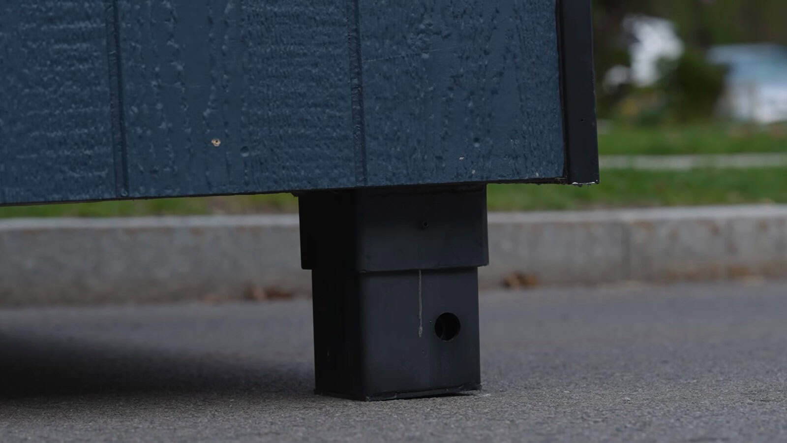 Close up of an Uplift Micro Home self-leveling support leg extended onto pavement