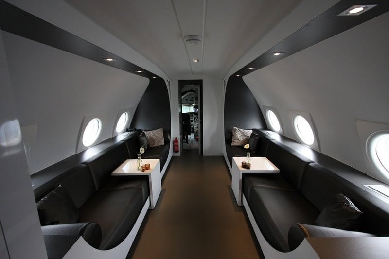 Two black sofas along the fuselage looking toward the original cockpit doorway