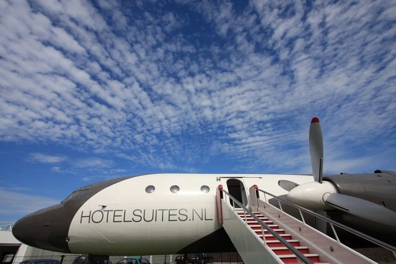 Boarding stairs with red rails to an open cabin door beside a turboprop engine and propeller