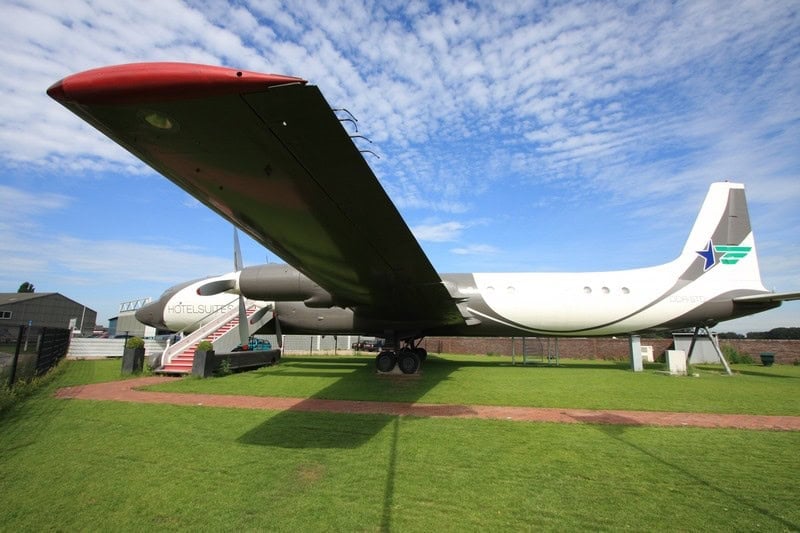 Three-quarter exterior of the airplane: DDR-STD on the tail, red-carpet stairs, HOTELSUITES.NL on the fuselage