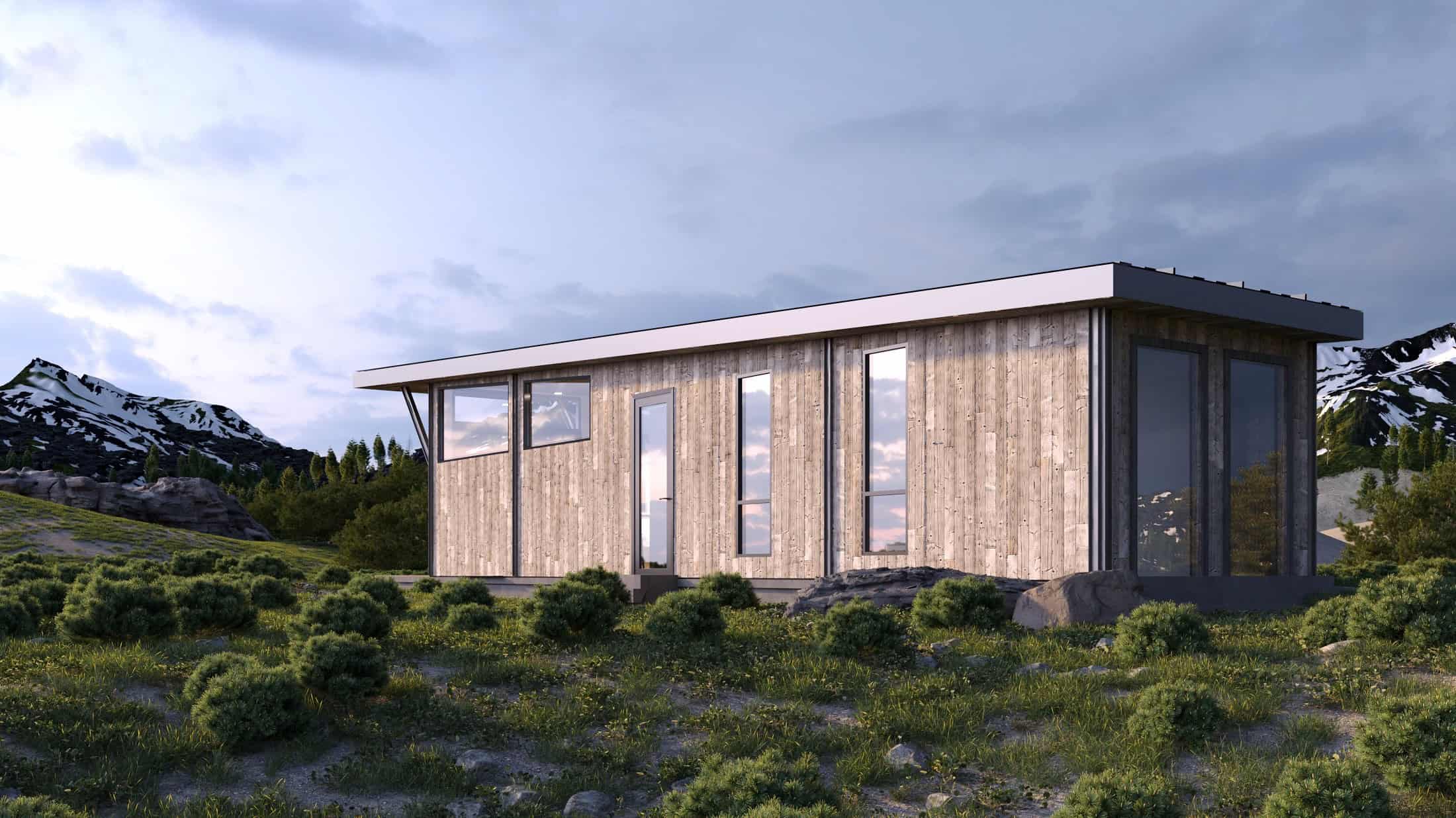 Side of the Wedge with gray reclaimed-wood siding, a flat overhanging roof, and tall narrow windows, set in mountain scrubland