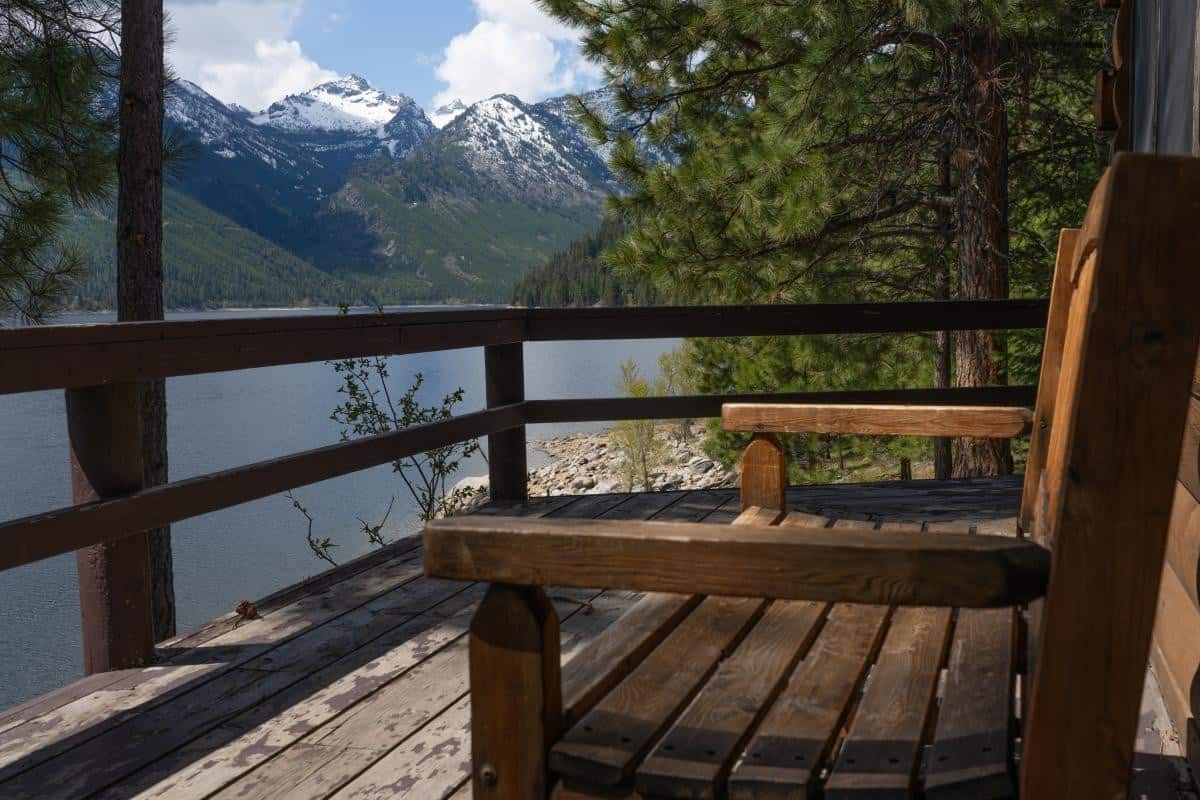 Rustic deck bench looking across Lake Como to snow-peaked Como Peaks