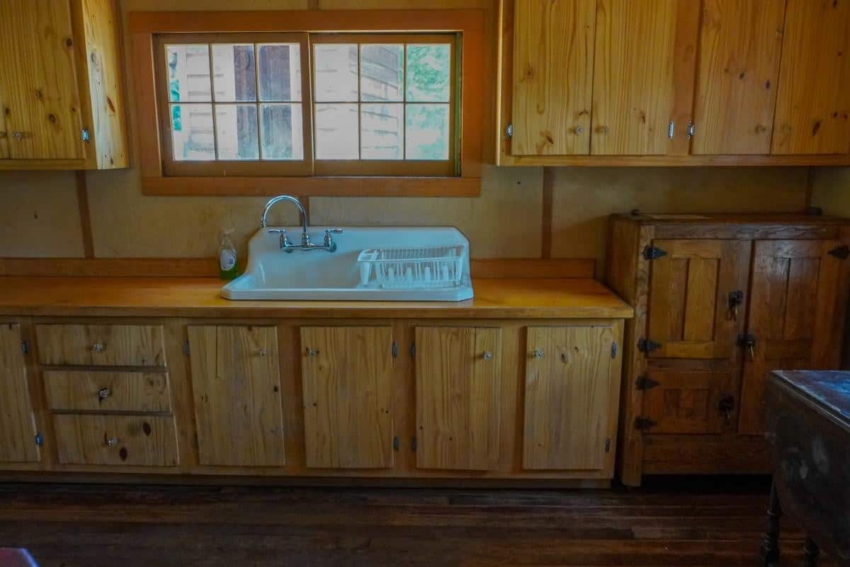 Woods Cabin kitchen with sink, wood counters, and window to the trees