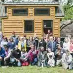 Group of people in front of a tiny house during building workshop.