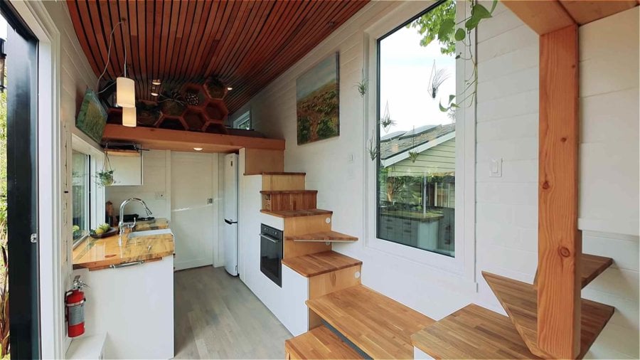 Galley kitchen with beetle-kill pine counters, wall oven and storage stairs leading to the loft