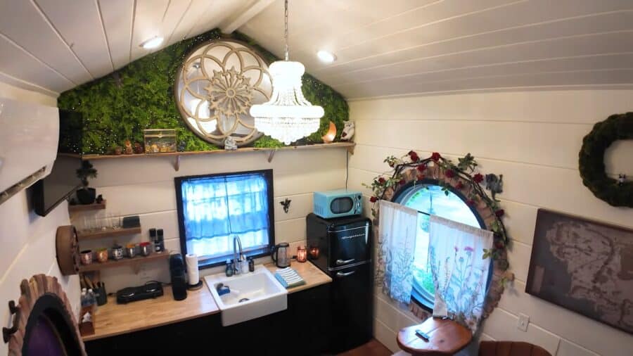 Cozy tiny home interior with dragon-themed decor and compact kitchen setup.