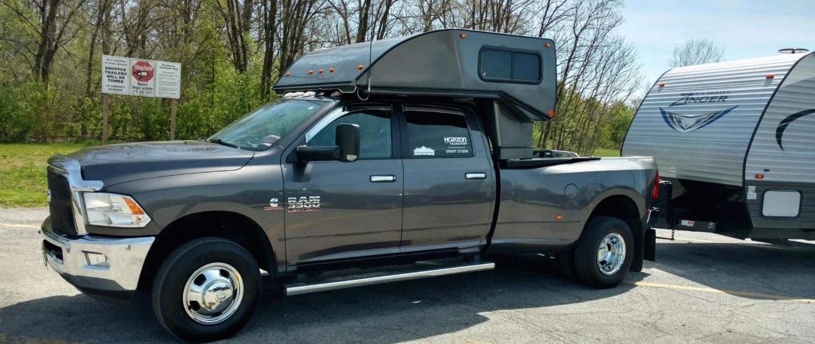Color-matched ZoomRoom over-the-cab sleeper on a pickup, zoomroom.space on the nose — official ZoomRoom / Inoventure Industries photo